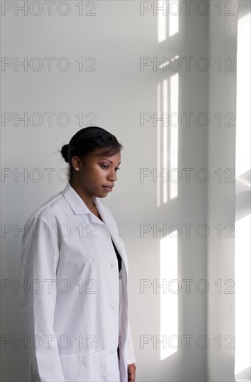 Serious doctor standing at window