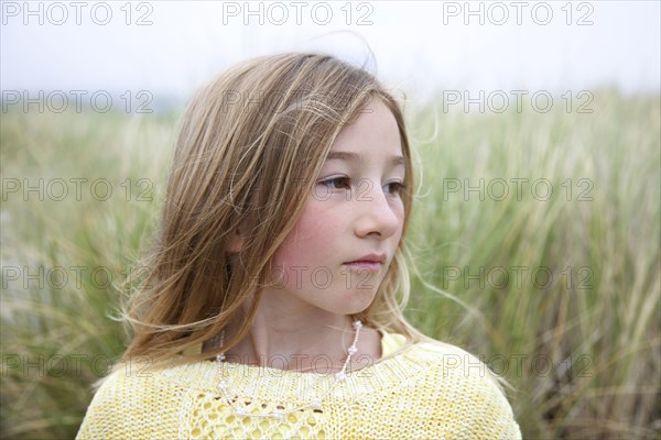 Mixed race girl standing in grass