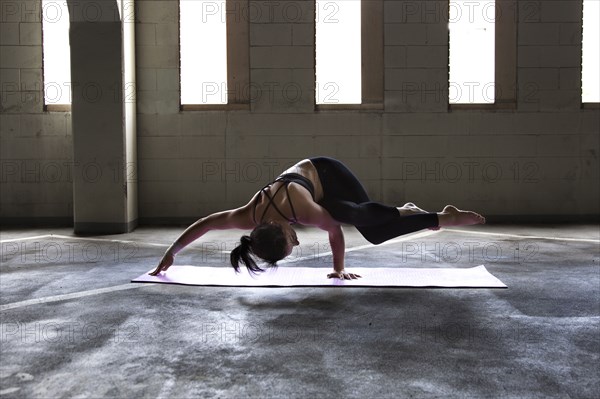 Caucasian woman practicing yoga in parking lot