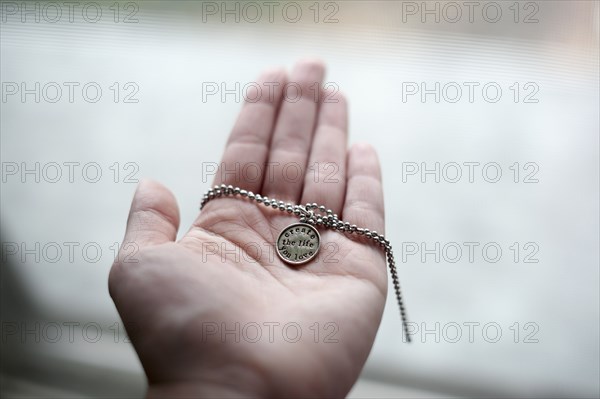 Hand of Caucasian woman holding necklace