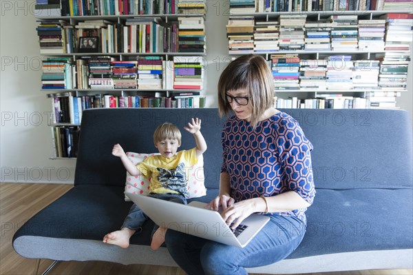 Mother and son using laptop