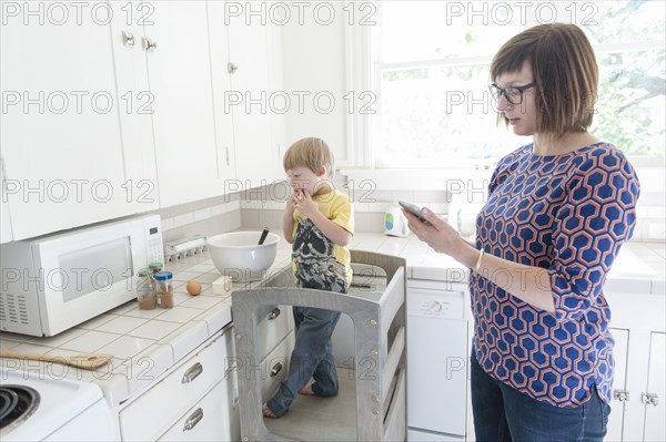 Mother and son standing in kitchen