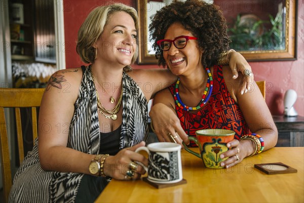 Hugging women drinking coffee