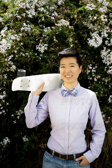 Androgynous woman holding skateboard
