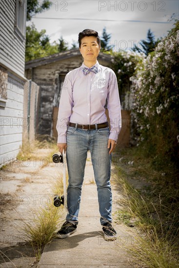 Androgynous woman holding skateboard