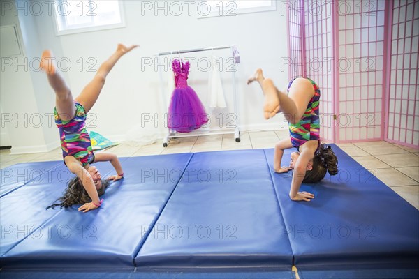 Twin sisters tumbling in gymnastics