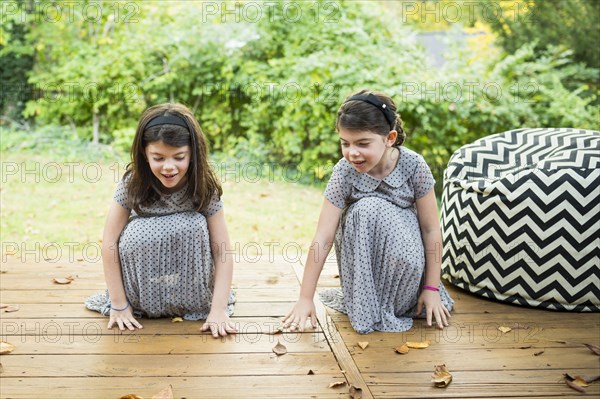 Twin sisters playing on deck