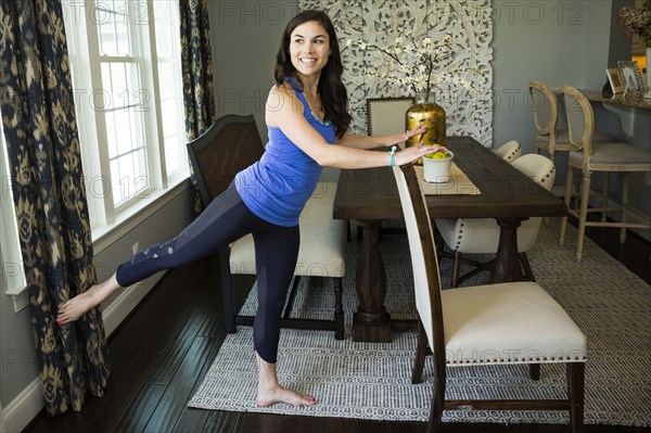 Woman stretching in dining room