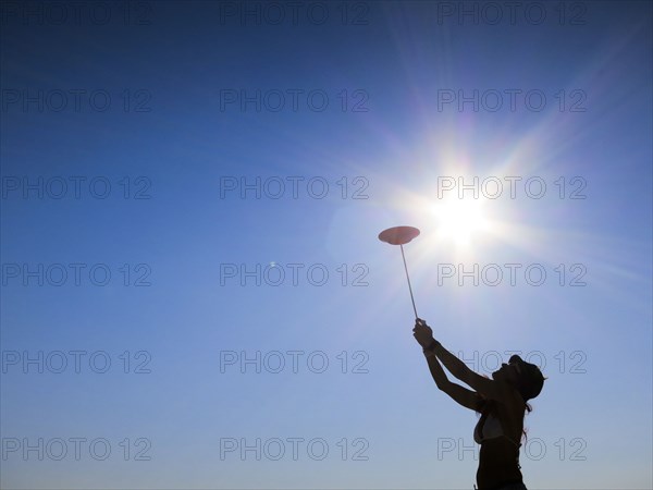 Silhouette of woman spinning plate