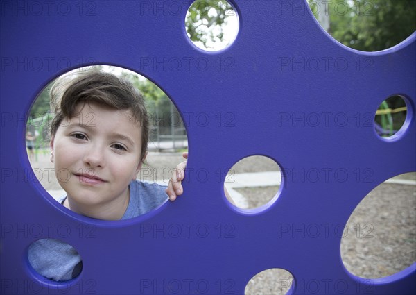 Caucasian girl peeking through play structure