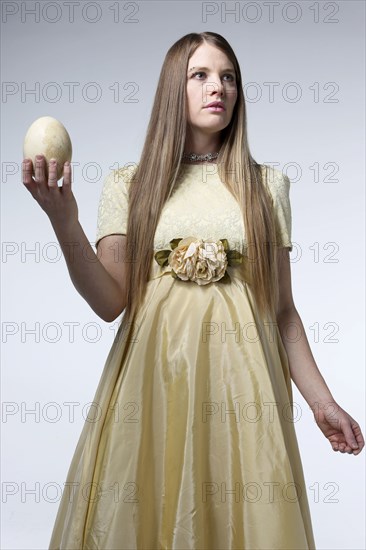 Woman in gown holding egg