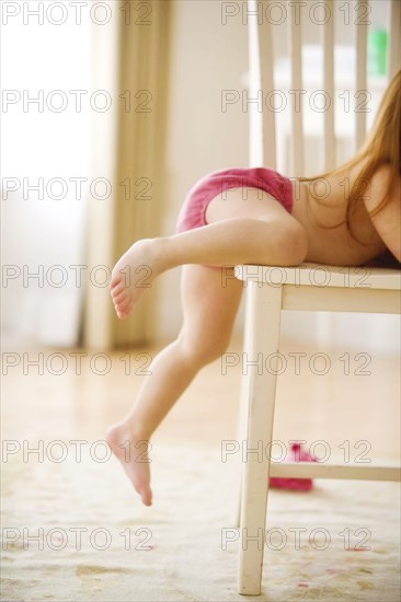 Side view of girl climbing chair