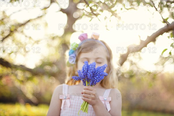 Caucasian girl smelling flowers outdoors