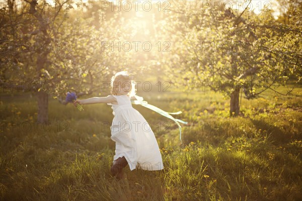 Caucasian girl spinning in grass