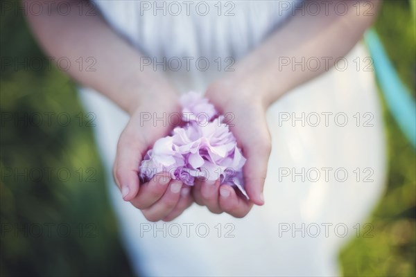 Caucasian girl holding flower petals