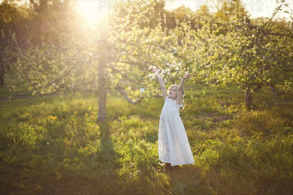 Caucasian girl tossing flower petals outdoors