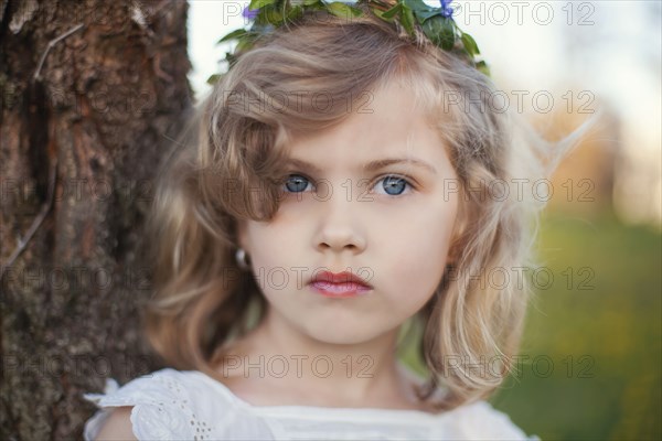 Serious Caucasian girl near tree