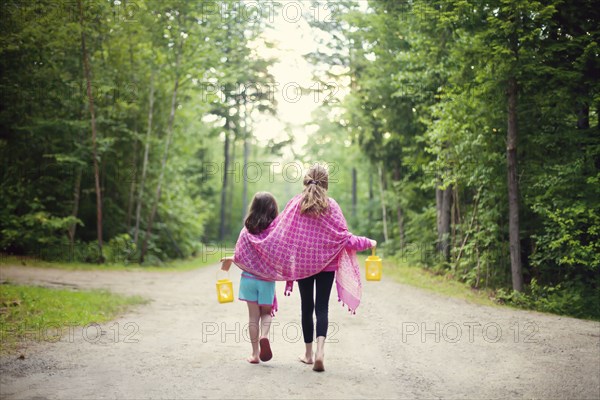 Caucasian sisters walking on dirt road