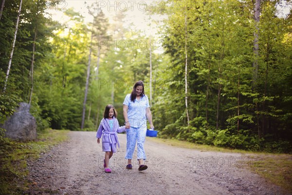 Caucasian mother and daughter walking on dirt road