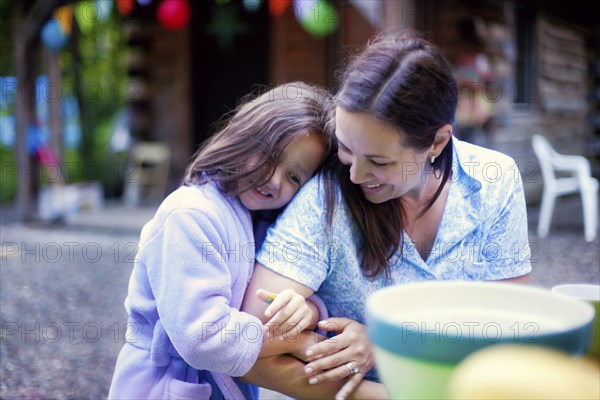 Caucasian girl hugging mother outdoors