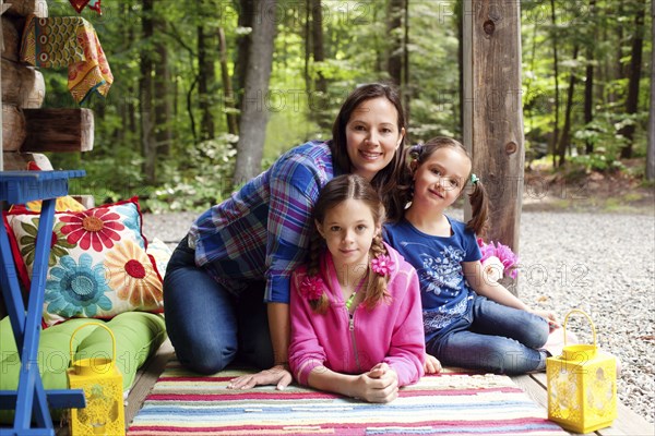 Caucasian mother and daughters smiling on porch