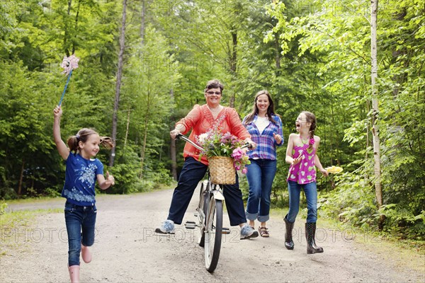 Three generations of Caucasian women walking on dirt road