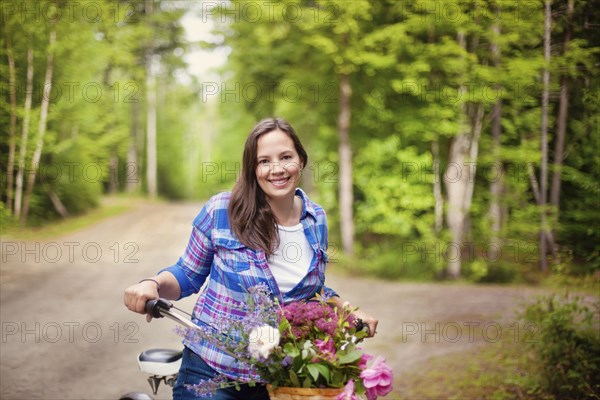 Caucasian woman with bicycle on dirt road
