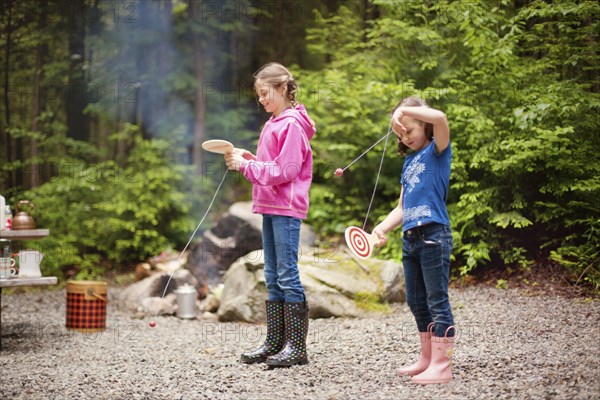 Caucasian girls playing with toys in forest