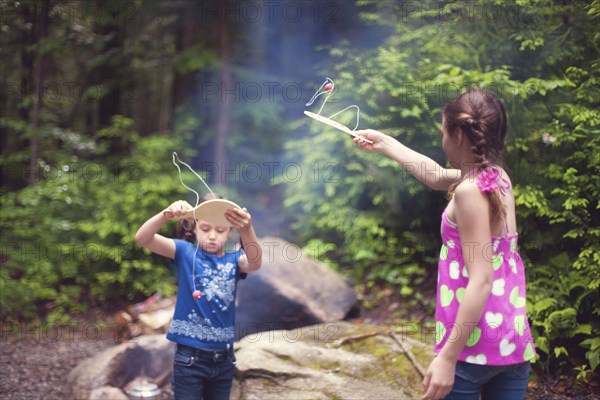 Caucasian girls playing with toys in forest