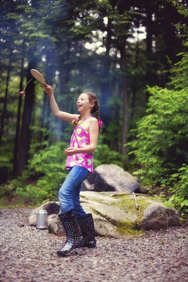 Caucasian girl playing with toy in forest