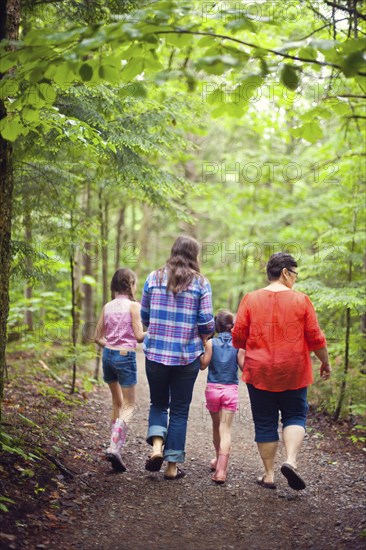 Three generations of Caucasian women walking in forest