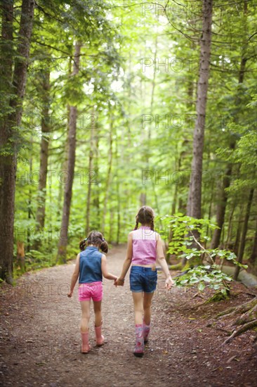 Caucasian sisters walking in forest