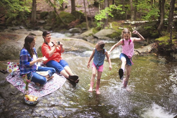 Three generations of Caucasian women playing in river