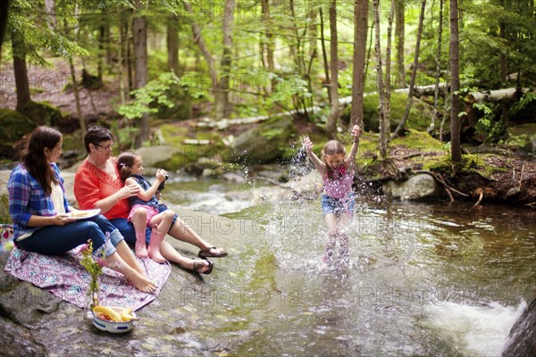 Three generations of Caucasian women playing in river