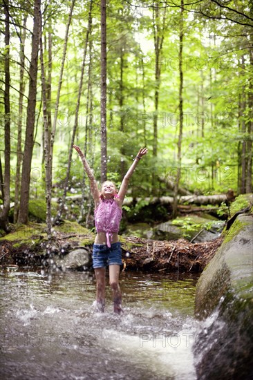 Caucasian girl splashing in river