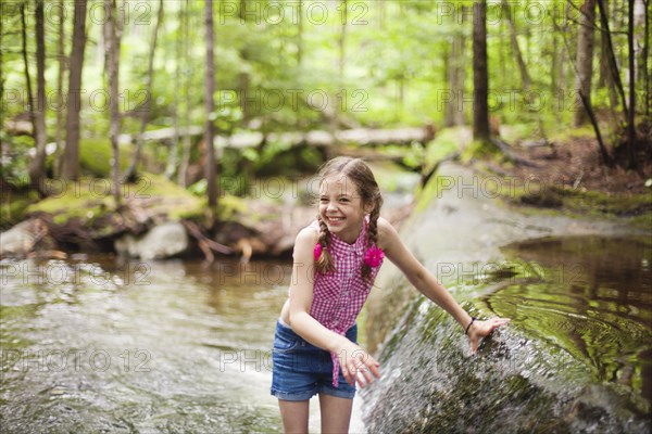 Caucasian girl laughing in river