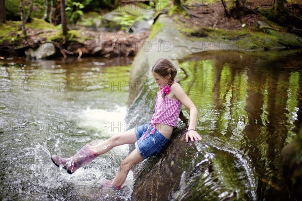 Caucasian girl splashing in river