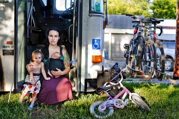 Mother and children sitting in bus doorway