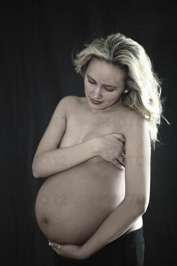 Pregnant Caucasian woman holding her belly