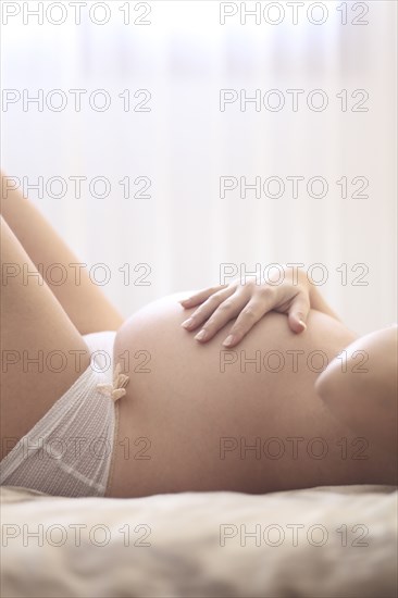 Pregnant Caucasian woman holding her belly