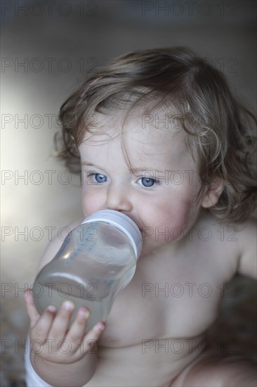 Caucasian baby girl drinking bottle