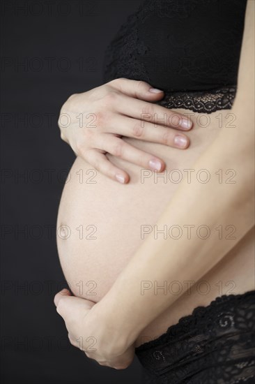 Close up of pregnant woman holding her belly