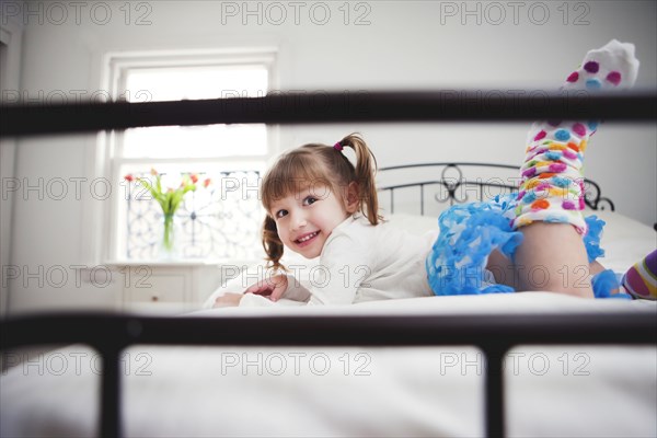 Smiling girl playing on bed
