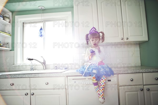 Girl sitting on kitchen counter