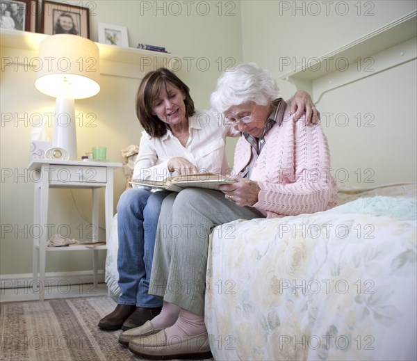 Mother and daughter looking at photo album