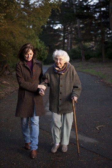 Woman walking with mother on paved path
