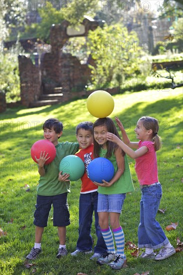 Children playing with balls in grass