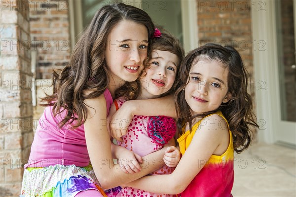 Playful sisters hugging outdoors