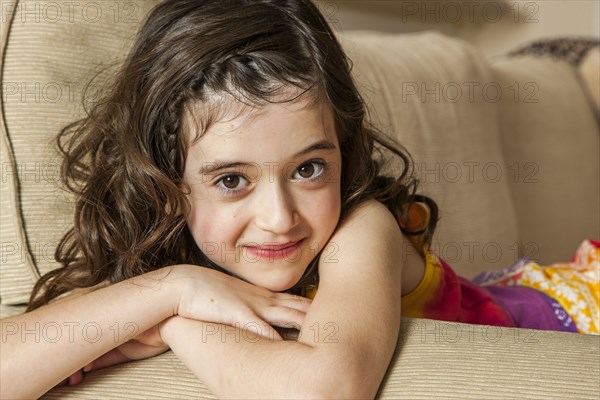 Smiling girl sitting on sofa