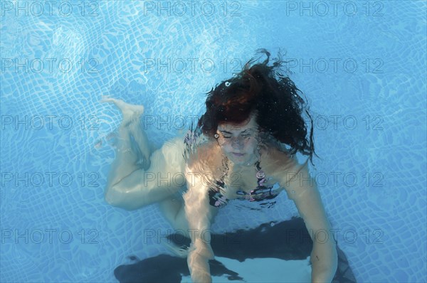 Caucasian woman swimming in pool